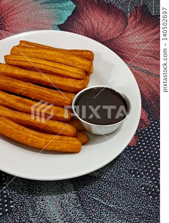 Churros, crispy and golden, dusted with sugar and cinnamon. A delicious, sweet treat often enjoyed with chocolate dipping sauce, perfect for satisfying any dessert craving. Churros, crispy and golden, dusted with sugar and cinnamon. A delicious, sweet treat often enjoyed with chocolate dipping sauce, perfect for satisfying any dessert craving. 140502697