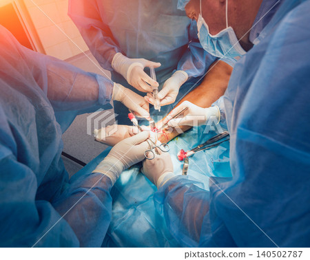 Process of trauma surgery operation. Group of surgeons in operating room with surgery equipment. 140502787