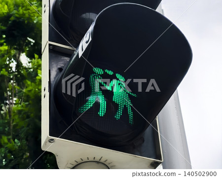 Green pedestrian traffic light with two gender figures, highlighting diversity awareness in modern public infrastructure. Green pedestrian traffic light with two gender figures, highlighting diversity awareness in modern public infrastructure. 140502900