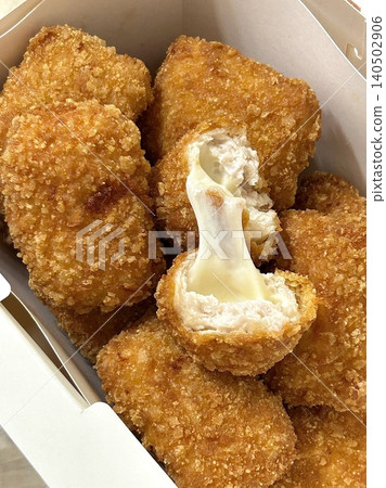 Crispy Korean fried chicken with golden coating served alongside spicy tteokbokki with chewy rice cakes in rich red sauce, creating a flavorful combination of crunchy and savory textures 140502906
