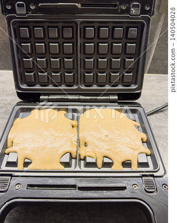 Delicious Waffle Batter Cooking in a Modern Waffle Iron, Capturing the Process of Making Freshly Made Breakfast Treats at Home Delicious Waffle Batter Cooking in a Modern Waffle Iron, Capturing the Process of Making Freshly Made Breakfast Treats at Home 140504028
