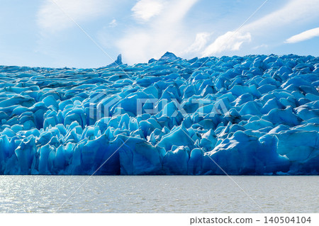 Patagonia glacier ice wall over water under bright sky Patagonia glacier ice wall over water under bright sky 140504104
