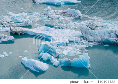 Perito Moreno glaciers in turquoise water with floating ice and drifting glacier fragments in cold polar scene Perito Moreno glaciers in turquoise water with floating ice and drifting glacier fragments in cold polar scene 140504188