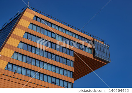 A Modern Architectural Marvel Featuring a Unique Cantilevered Structure Against a Clear Blue Sky, Showcasing Innovative Design and Contemporary Materials 140504433