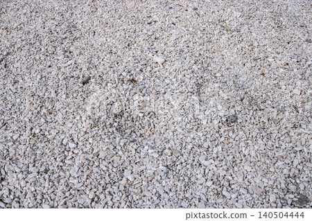 A Close-Up View of a Textured Surface Composed of Small Grey and White Stones, Perfect for Landscaping or Construction Applications 140504444