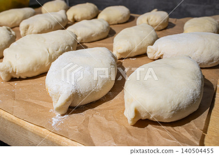 Freshly Made Dough Pieces Ready for Baking, Perfectly Shaped and Dusting with Flour for Optimal Texture and Flavor in Artisan Bread Preparation Freshly Made Dough Pieces Ready for Baking, Perfectly Shaped and Dusting with Flour for Optimal Texture and Flavor in Artisan Bread Preparation 140504455