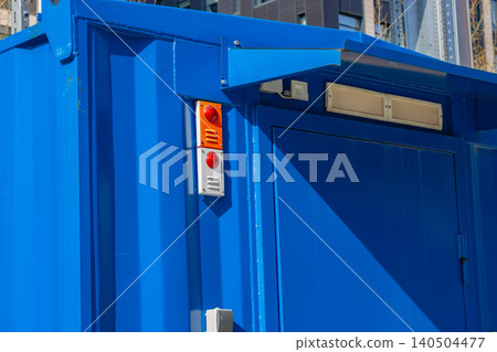 Vibrant Blue Container with Signals and Architectural Details Showcasing Modern Industrial Design Elements in Urban Landscape 140504477