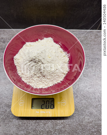 A Close-Up View of a Bowl Filled with Flour on a Digital Scale Displaying the Weight in Grams A Close-Up View of a Bowl Filled with Flour on a Digital Scale Displaying the Weight in Grams 140504486