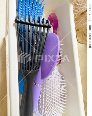 A Colorful Array of Hairbrushes and Combs Organized in a Container for Personal Grooming and Hair Care Needs A Colorful Array of Hairbrushes and Combs Organized in a Container for Personal Grooming and Hair Care Needs 140504488