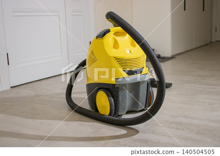 A Bright Yellow Vacuum Cleaner Positioned on a Clean, Light-Colored Floor in a Minimalist Indoor Setting, Highlighting Modern Cleaning Tools A Bright Yellow Vacuum Cleaner Positioned on a Clean, Light-Colored Floor in a Minimalist Indoor Setting, Highlighting Modern Cleaning Tools 140504505