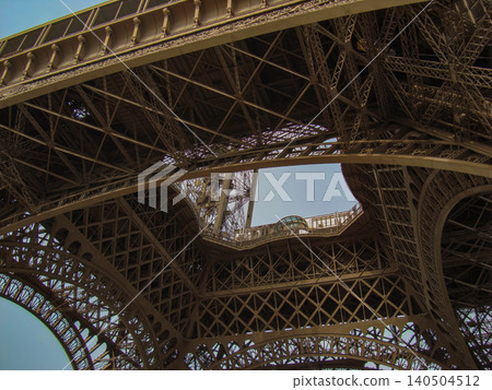 A Captivating Perspective of the Intricate Iron Framework of a Famous Tower, Showcasing the Architectural Brilliance from Below 140504512