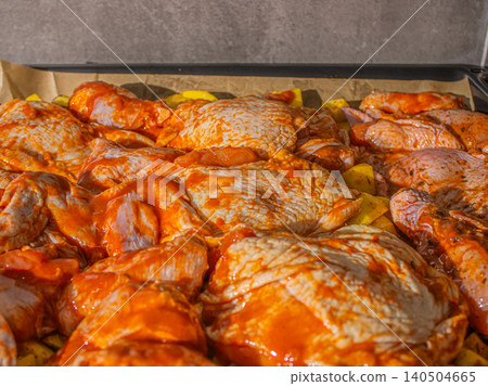 An Array of Flavorful Marinated Chicken Thighs Ready for Grilling, Surrounded by Wholesome Potatoes in a Rustic Kitchen Setting An Array of Flavorful Marinated Chicken Thighs Ready for Grilling, Surrounded by Wholesome Potatoes in a Rustic Kitchen Setting 140504665