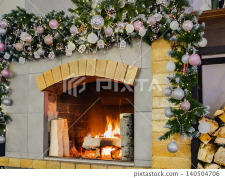 A Cozy Fireplace Surrounded by Holiday Decorations and Warm Glow of a Fire, Creating a Festive Atmosphere for Winter Celebrations A Cozy Fireplace Surrounded by Holiday Decorations and Warm Glow of a Fire, Creating a Festive Atmosphere for Winter Celebrations 140504706