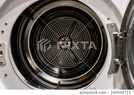 Interior View of a Modern, High-Efficiency Clothes Dryer Drum Showcasing Its Unique Honeycomb Pattern for Optimal Fabric Care and Energy Efficiency 140504715
