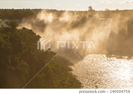 Majestic iguazu falls bathed in warm golden light showing breathtaking mist and river Majestic iguazu falls bathed in warm golden light showing breathtaking mist and river 140504759