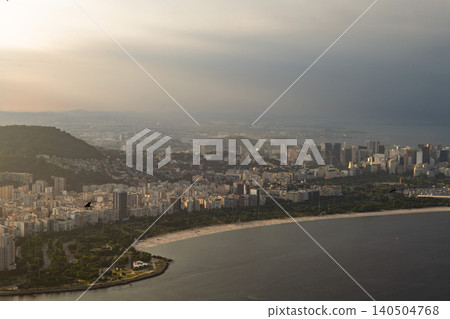 Calm aerial view of rio de janeiro cityscape showing coastline and beach during hazy sunrise 140504768