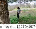 Young girl with crutches standing in a grassy field 140504937