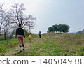 Children walking toward a girl with crutches in a field 140504938