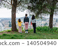 Three children overlooking a small town from a hilltop viewpoint 140504940