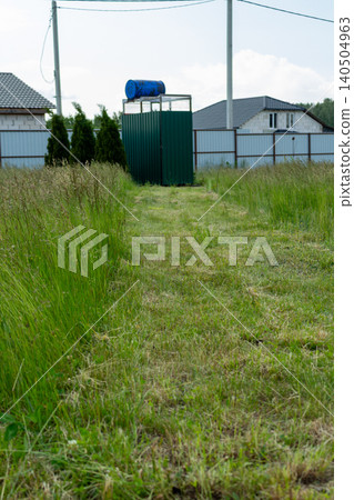 High green grass blowing in the wind on a backyard lawn. Summer garden care, estate maintenance before mowing 140504963