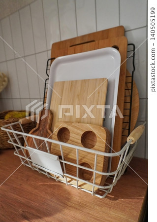 An Aesthetic Arrangement of Wooden and Bamboo Cutting Boards in a Kitchen Basket Storage An Aesthetic Arrangement of Wooden and Bamboo Cutting Boards in a Kitchen Basket Storage 140505199
