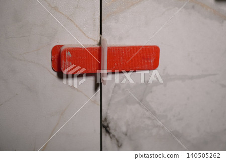 Close-Up Image of a Red Plastic Clip Used for Securing Two Surfaces Together in a Modern Environment 140505262