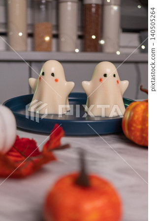 Cute ghost decorations on blue tray with mini pumpkins in festive autumn setting 140505264