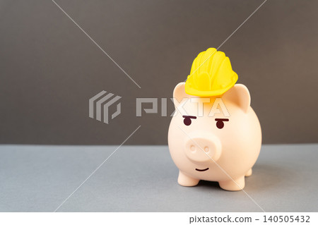 A piggy bank in a yellow builder's helmet. Savings on construction and renovations. Cashback and trade promotions. A piggy bank in a yellow builder's helmet. Savings on construction and renovations. Cashback and trade promotions. 140505432