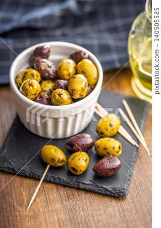 Marinated Green And Kalamata Olives In White Ramekin With Toothpicks On Slate 140505585