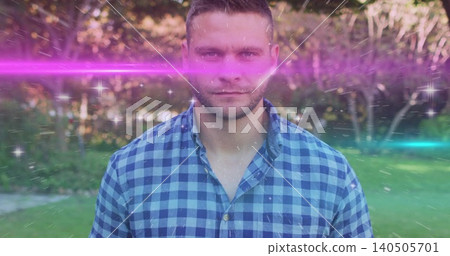 Standing mid-adult man facing camera in checked shirt at park with magenta and teal streaks, stars Standing mid-adult man facing camera in checked shirt at park with magenta and teal streaks, stars 140505701
