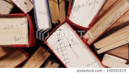 Showing radial cluster of hardcovers with red blue spines at desk, revealing math on page edges Showing radial cluster of hardcovers with red blue spines at desk, revealing math on page edges 140505819