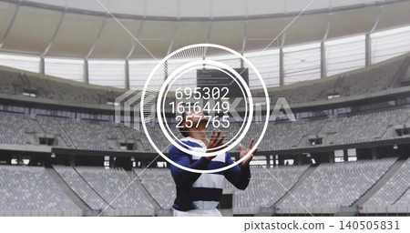 Standing male athlete raising hands in covered stadium, wearing navy-striped kit with HUD numbers Standing male athlete raising hands in covered stadium, wearing navy-striped kit with HUD numbers 140505831