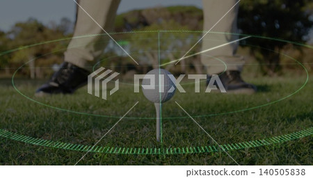 Framing golf ball on tee at golf course, showing green AR rings, beige trousers, black shoes Framing golf ball on tee at golf course, showing green AR rings, beige trousers, black shoes 140505838