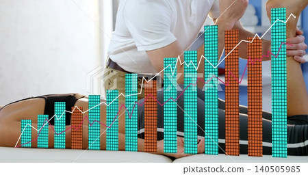 Kneeling clinician in white polo moving leg on clinic table, patient in black shorts, chart overlay Kneeling clinician in white polo moving leg on clinic table, patient in black shorts, chart overlay 140505985