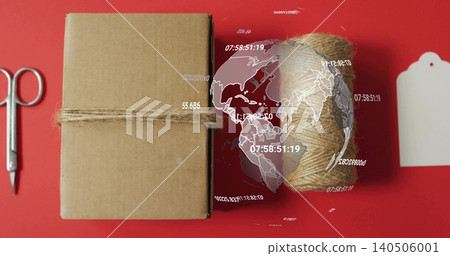 Wrapping kraft parcel with jute twine on red backdrop, showing scissors tag globe, copy space Wrapping kraft parcel with jute twine on red backdrop, showing scissors tag globe, copy space 140506001