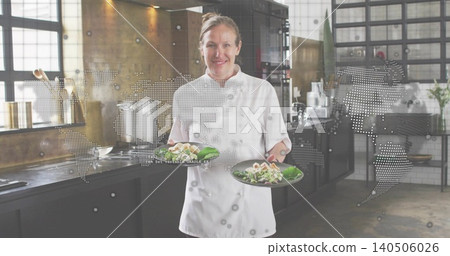 Presenting chef wearing white chef jacket holding two plated salads in kitchen, world map overlay Presenting chef wearing white chef jacket holding two plated salads in kitchen, world map overlay 140506026