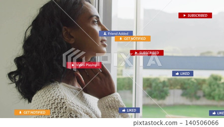 Standing woman touching neck, looking out big window in room in cream sweater, badges, copy space Standing woman touching neck, looking out big window in room in cream sweater, badges, copy space 140506066