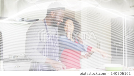 Preparing couple at home kitchen wearing striped apron and red top mixing eggs in green bowl Preparing couple at home kitchen wearing striped apron and red top mixing eggs in green bowl 140506161