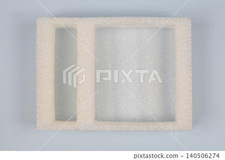 White protective foam packaging insert on light blue background White protective foam packaging insert on light blue background 140506274