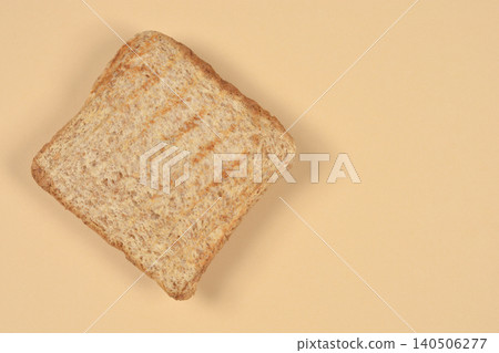 Single slice of whole wheat toast on beige background Single slice of whole wheat toast on beige background 140506277