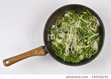 Chopped Fresh Leeks in a Frying Pan on White Background Chopped Fresh Leeks in a Frying Pan on White Background 140506293