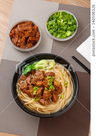Traditional Chinese Braised Beef Rice Noodles with Bok Choy and Scallions. Authentic Asian Beef Noodle Soup in black Bowl. 140506326