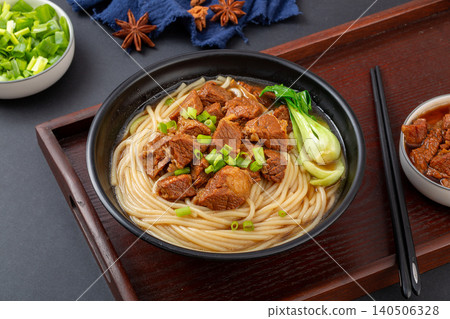 Traditional Chinese Braised Beef Rice Noodles with Bok Choy and Scallions. Authentic Asian Beef Noodle Soup in black Bowl. 140506328