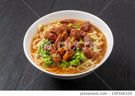 Signature Chinese Braised Beef Noodles with Peanuts and Pickles. Hearty Beef Ramen Bowl with Chili Oil and Vegetables. 140506329