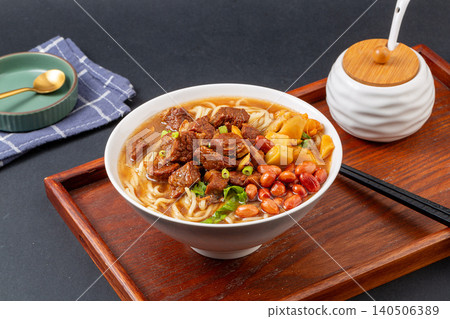 Signature Chinese Braised Beef Noodles with Peanuts and Pickles. Hearty Beef Ramen Bowl with Chili Oil and Vegetables. 140506389