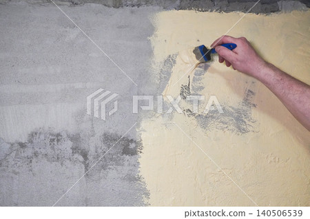 Person paints a wall yellow while waterproofing a bathroom under tiles. Person paints a wall yellow while waterproofing a bathroom under tiles. 140506539