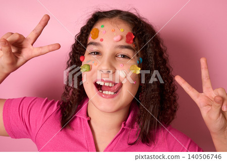 A Joyful Girl Covered in Colorful Candy and Treats with a Fun Pink Background Greeting You 140506746