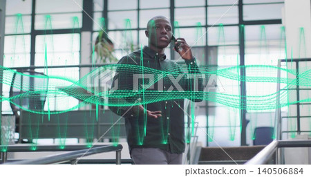 Talking business-casual man holding smartphone and gesturing on atrium landing, with green waveform Talking business-casual man holding smartphone and gesturing on atrium landing, with green waveform 140506884