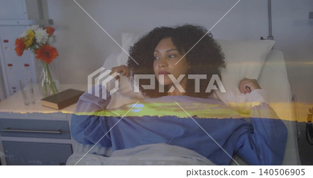 Reclining patient wearing blue long-sleeve top and white blanket in hospital bed, sunset overlay Reclining patient wearing blue long-sleeve top and white blanket in hospital bed, sunset overlay 140506905