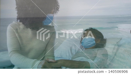 Holding adult hand, child leaning beside patient in hospital bed wearing gown, blue masks, sea view Holding adult hand, child leaning beside patient in hospital bed wearing gown, blue masks, sea view 140506906
